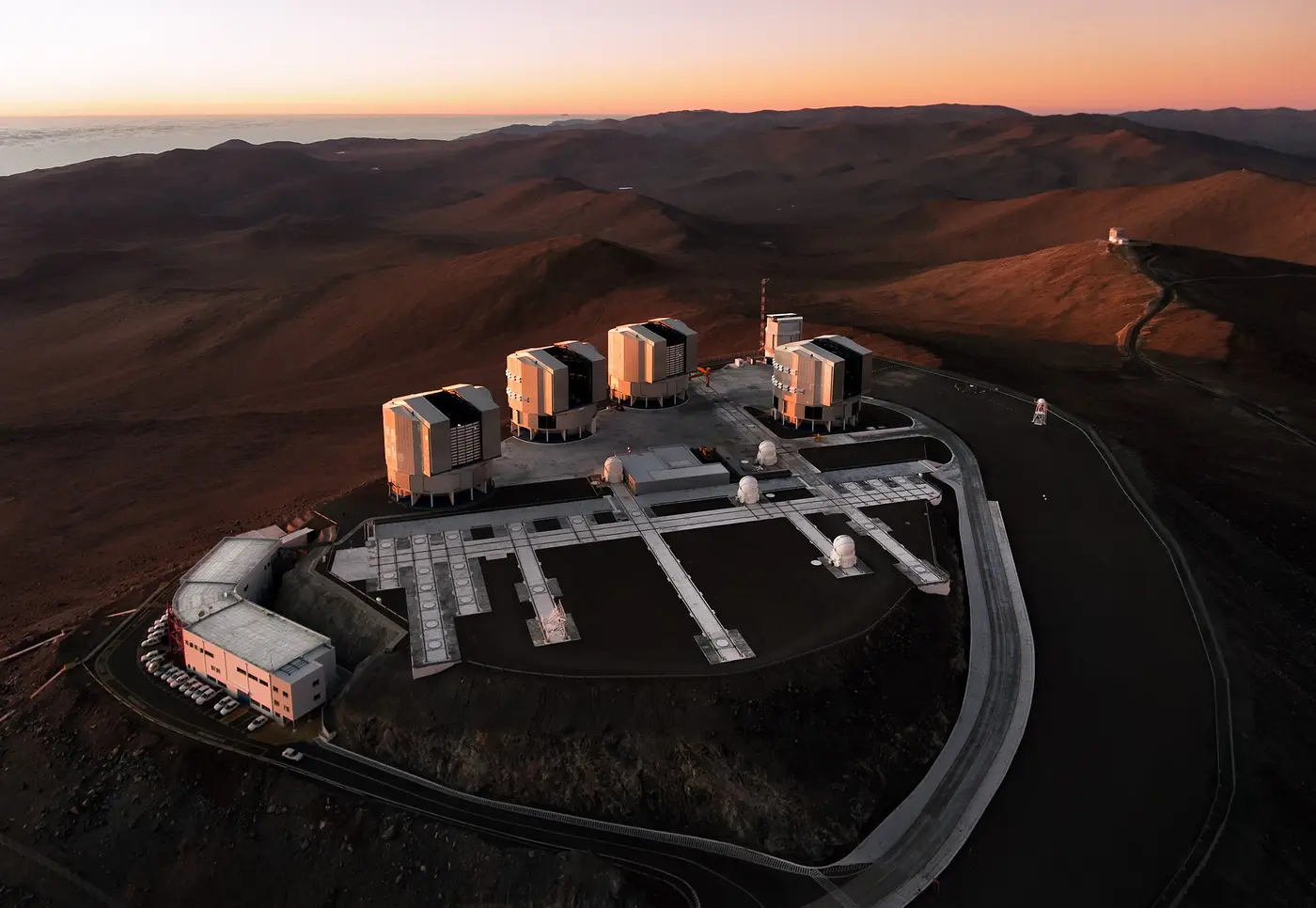 Aerial view of hilltop buildings and desert ridges at sunset