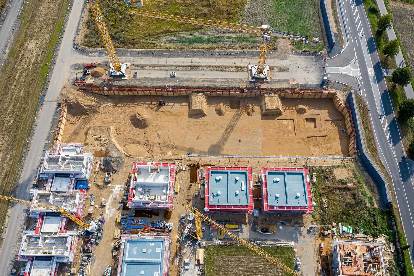 Aerial drone view looking straight down on a housing construction site with foundations and cranes